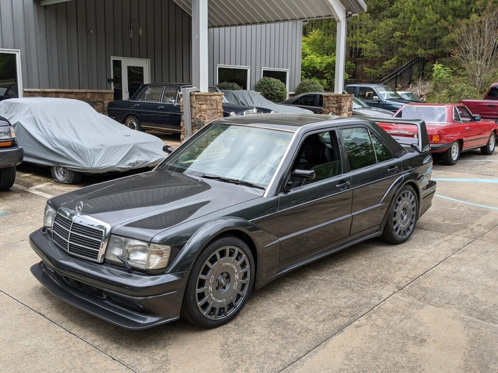 Schwarz-farbener Mercedes-Benz 190E 2.5-16 Evo II aus dem Jahr 1991, der im Freien geparkt ist.